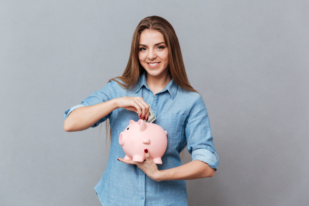 woman putting money piggy bank
