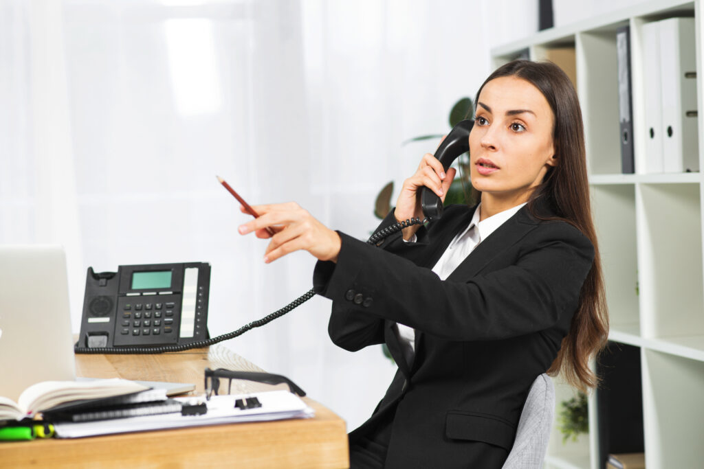 young businesswoman talking telephone pointing pencil somewhere